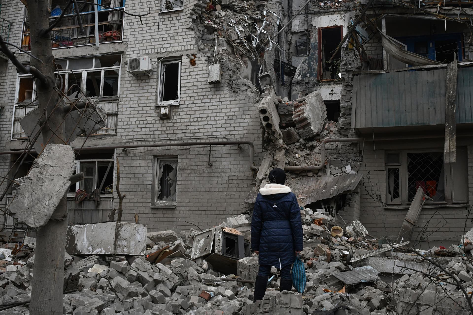 A woman stands among debris of the destroyed house after recent Russian air strike in Chasiv Yar