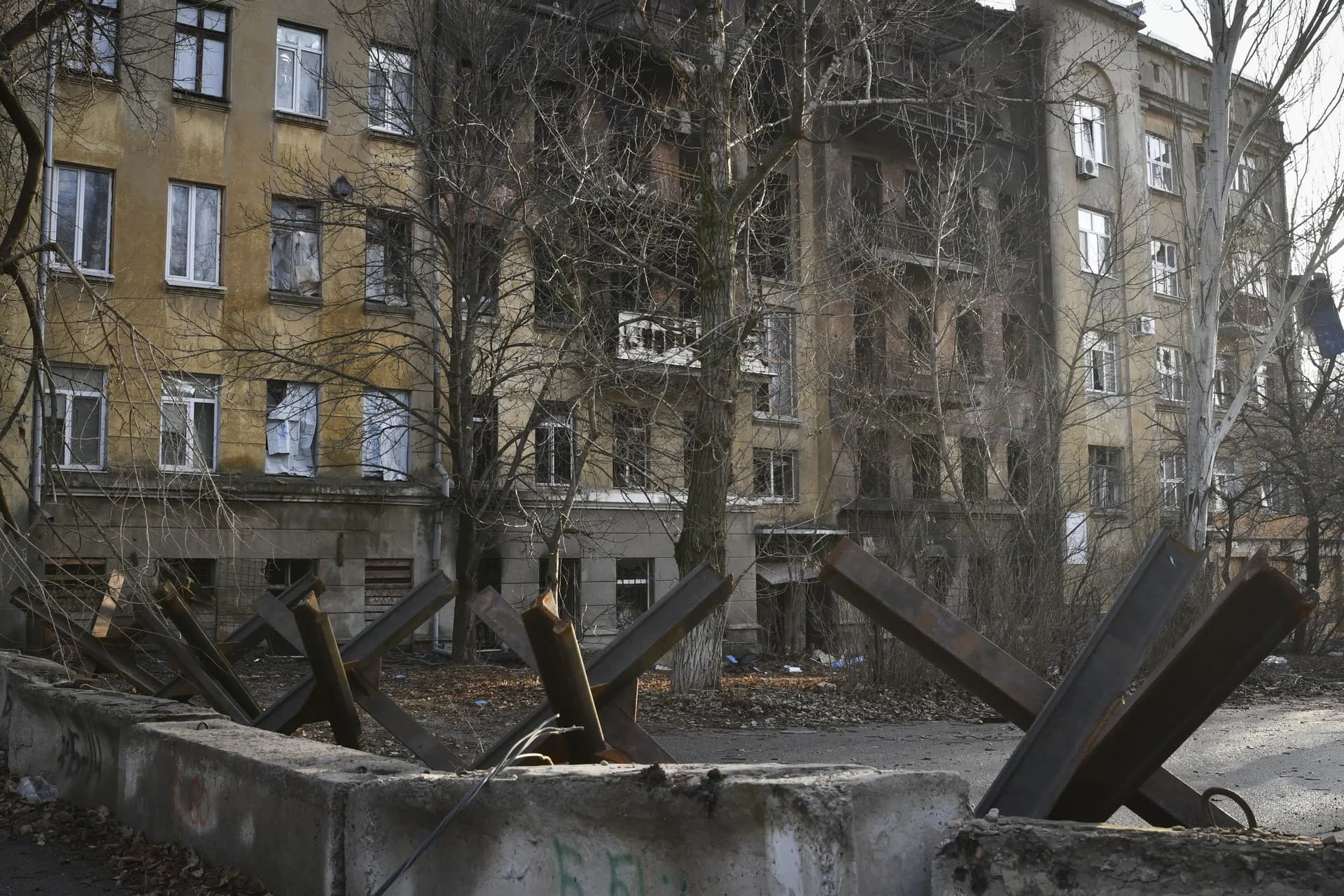 Anti-tank hedgehogs against the background of an apartment house damaged in the Russian shelling in Bakhmut