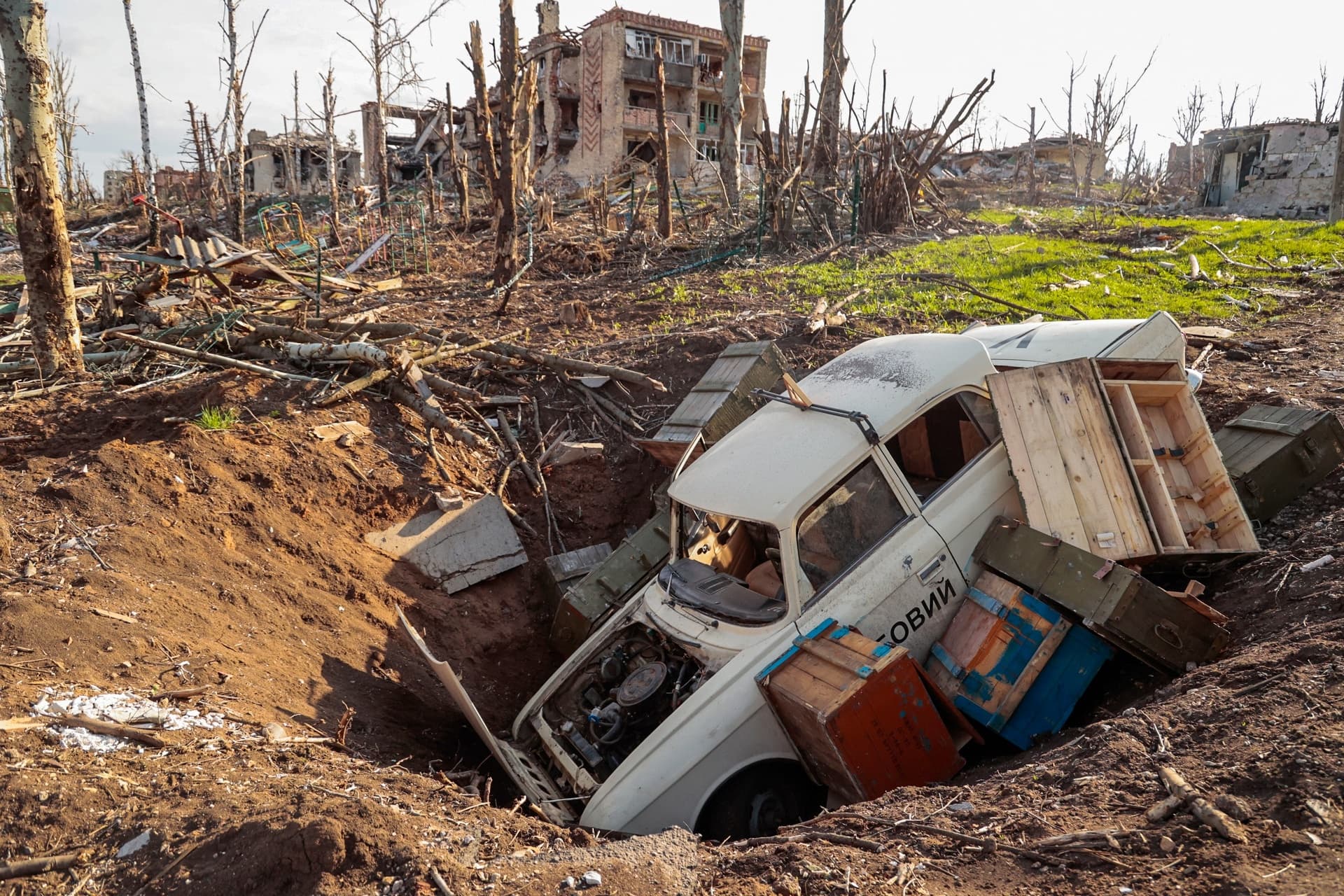 A car and ammunition boxes in a crater in Bakhmut