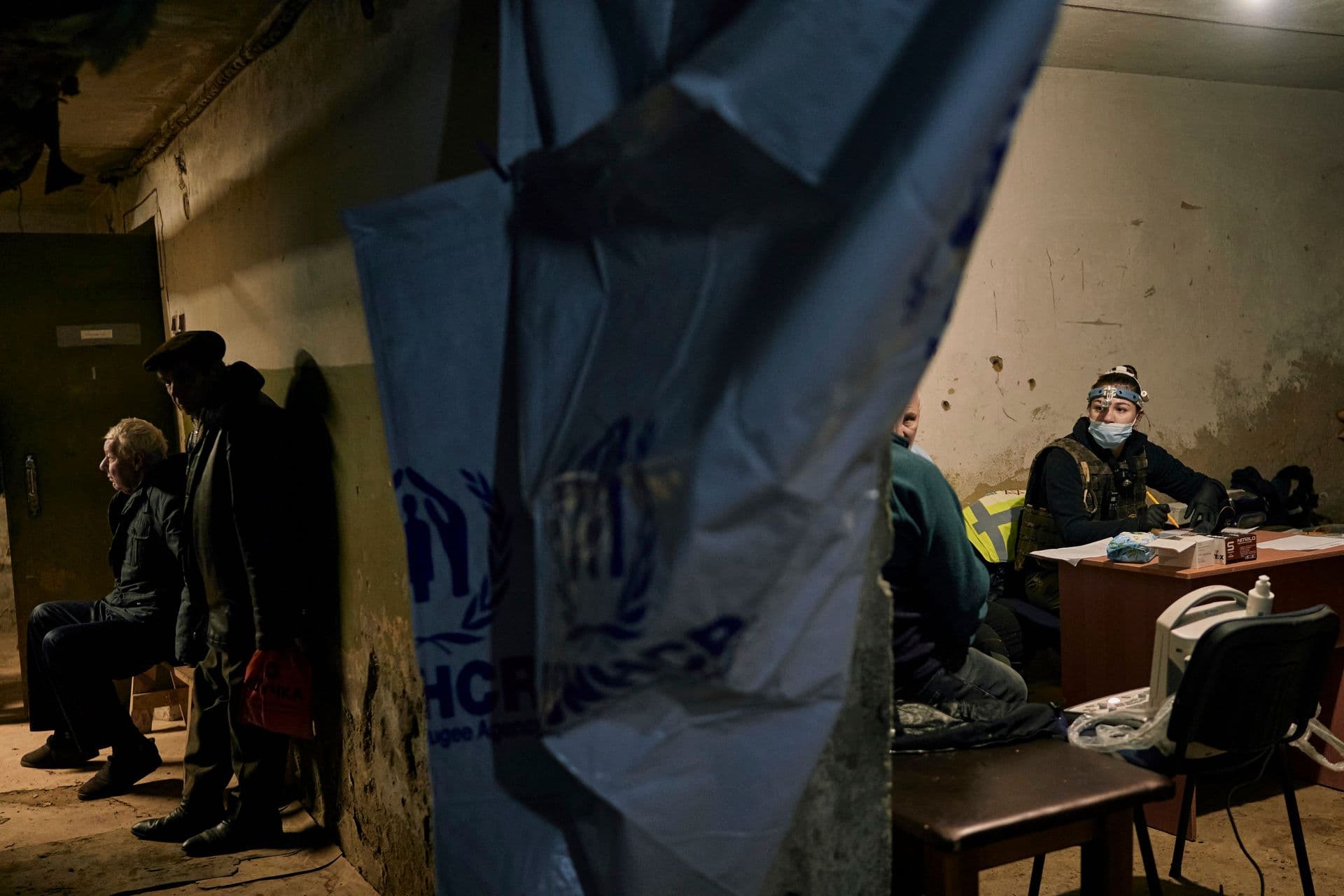 Local residents wait for their turn to get a medical aid from charitable organization Frida volunteers in a basement in Bakhmut