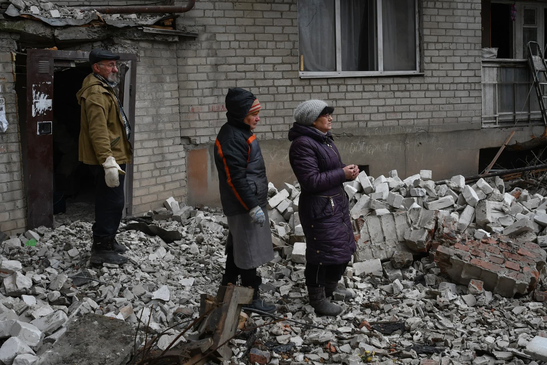Local residents react near the destroyed house after recent Russian air strike in Chasiv Yar