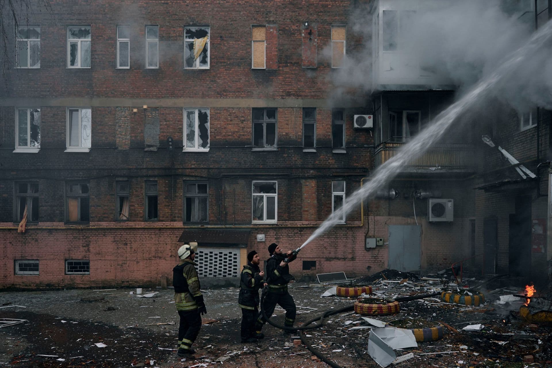 Emergency workers put out the fire after Russian shelling hit an apartment building in Bakhmut