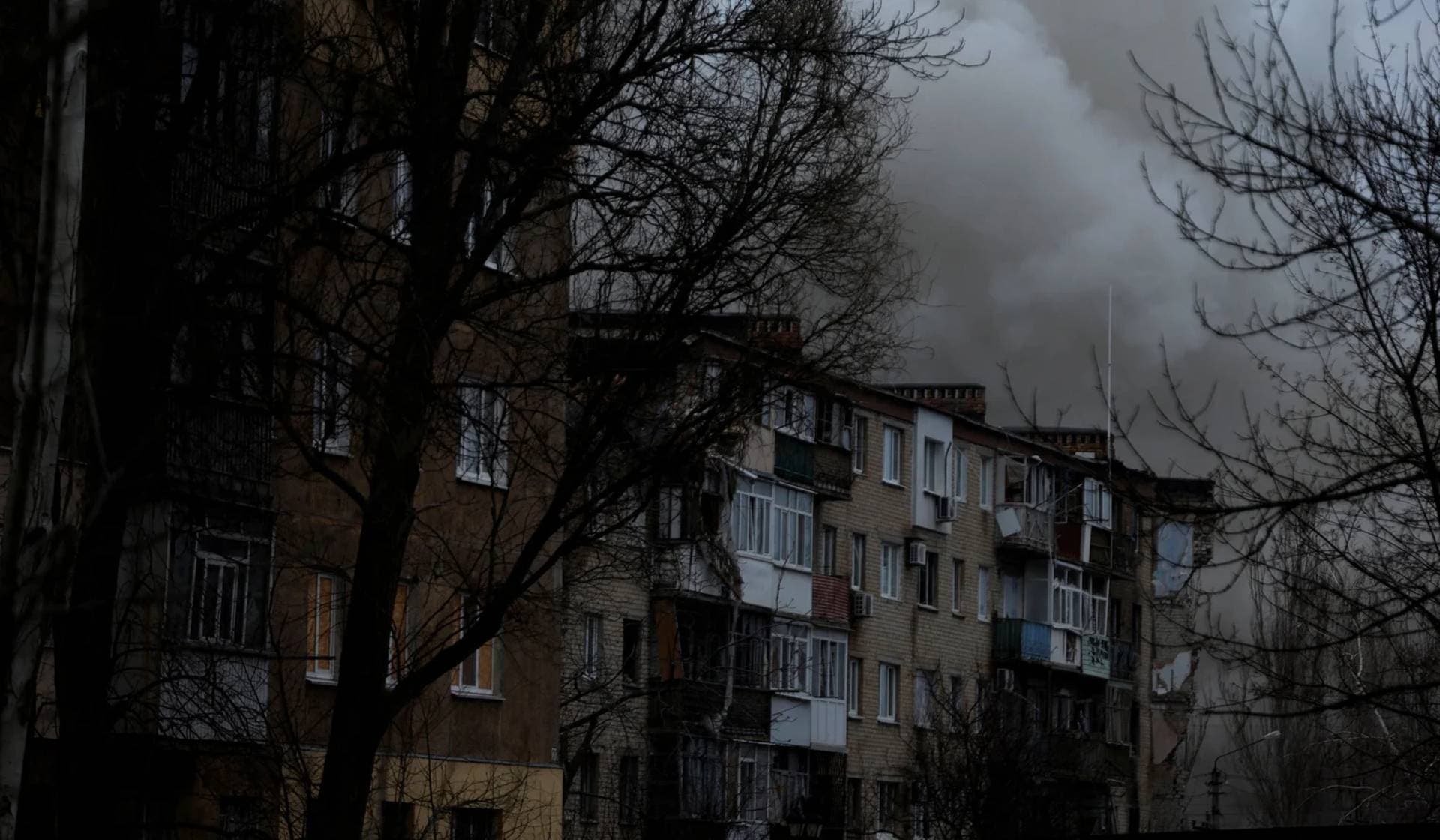 Smoke rises from apartment buildings damaged from missile strikes during intense shelling on Christmas Day at the frontline in Bakhmut
