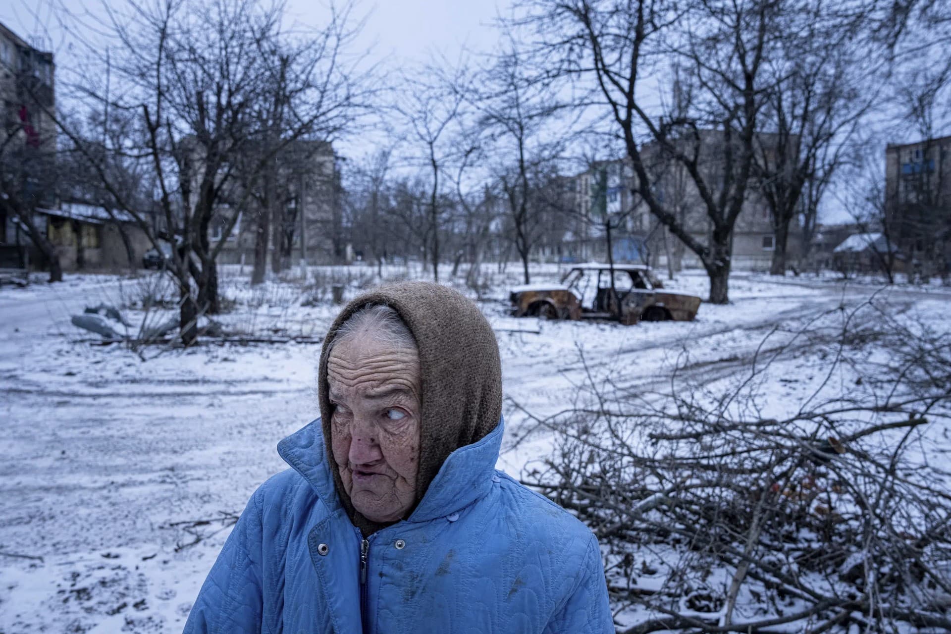 Nina Klinkova reacts to a sound of an explosion as she looks for humanitarian aid in Siversk