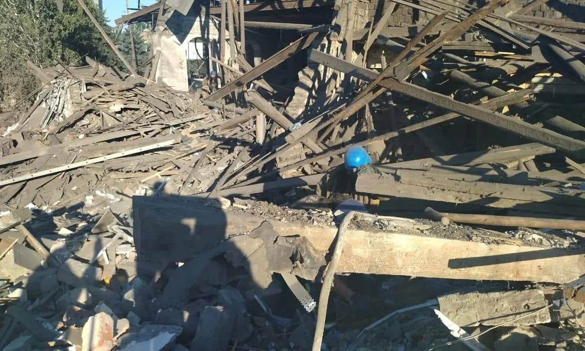 Rescue workers in blue helmets were digging through debris and clearing rubble from a collapsed two-storey building in Toretsk