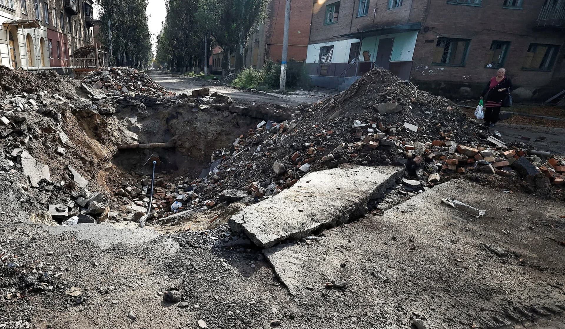 A local resident walks past a destroyed building in Bakhmut