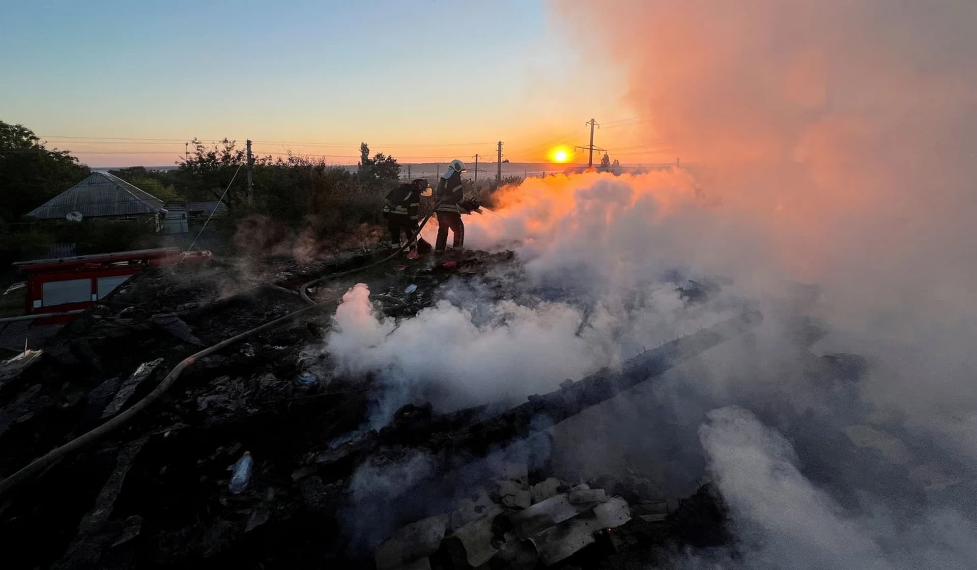 A Ukrainian firefighter puts out fire in a residential house after a Russian military strike in Bakhmut