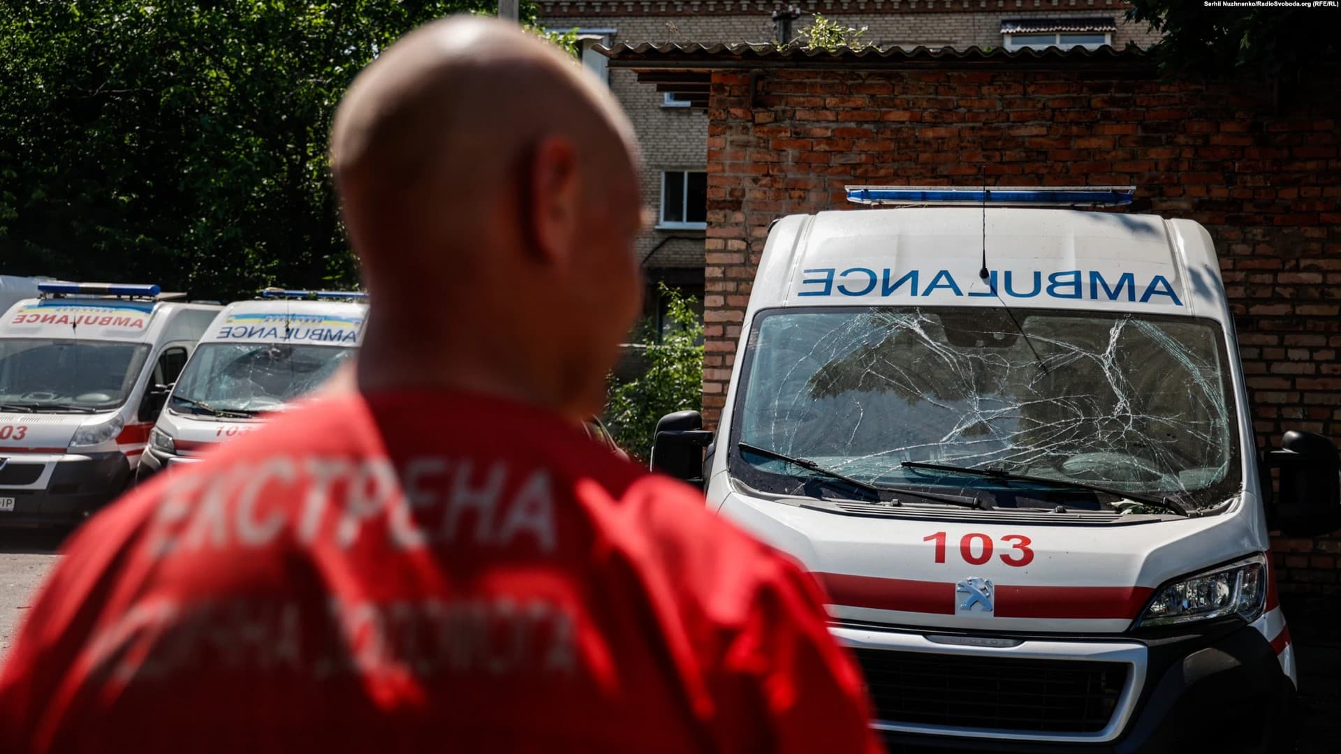 A medical worker observes damaged ambulances in Bakhmut