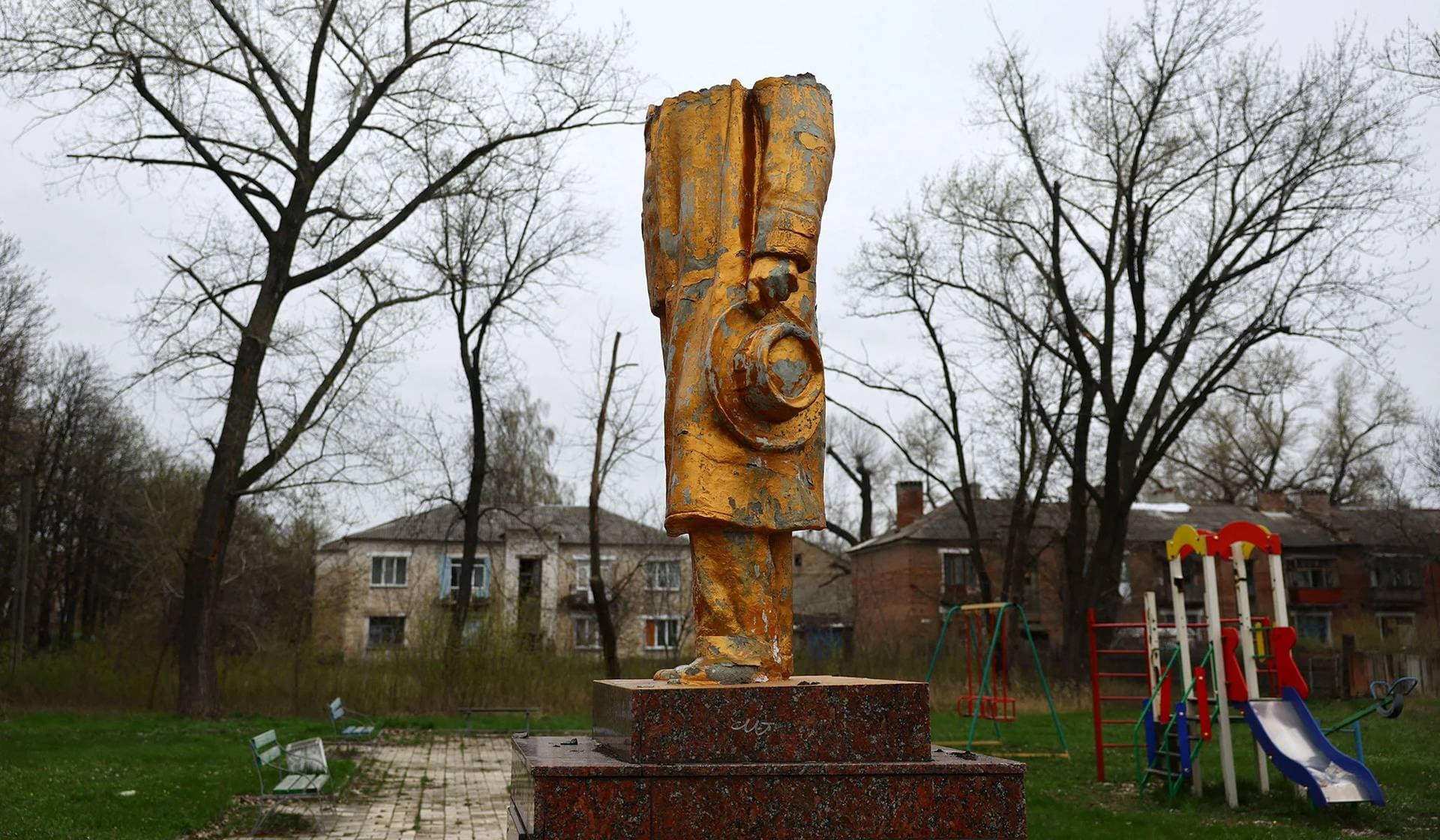 The cut apart statue of Russian writer Maxim Gorki remains near a playground during heavy fighting at the frontline in Chasiv Yar
