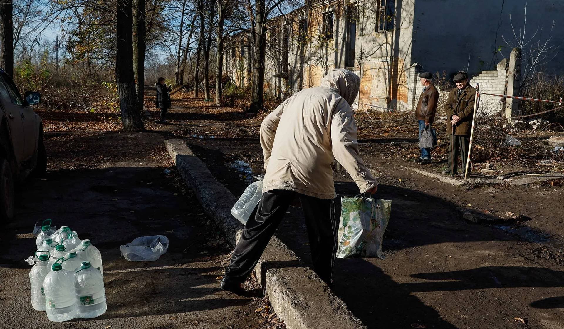 A local resident take bottles with drinking water from humanitarian aid delivered by volunteers in the town of Chasiv Yar