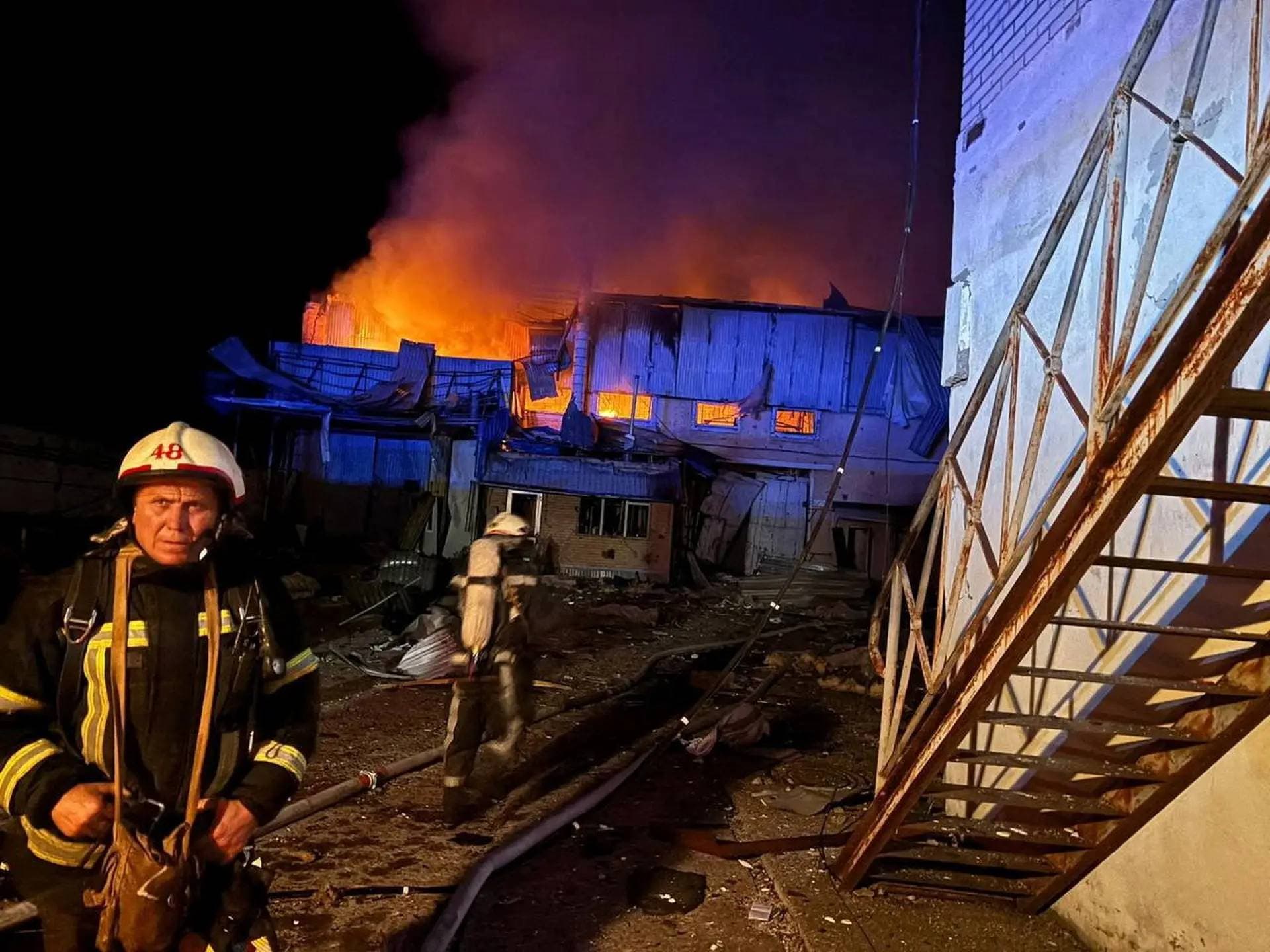 Firefighters work at the site of car garages hit by a Russian drone strike in Bila Tserkva
