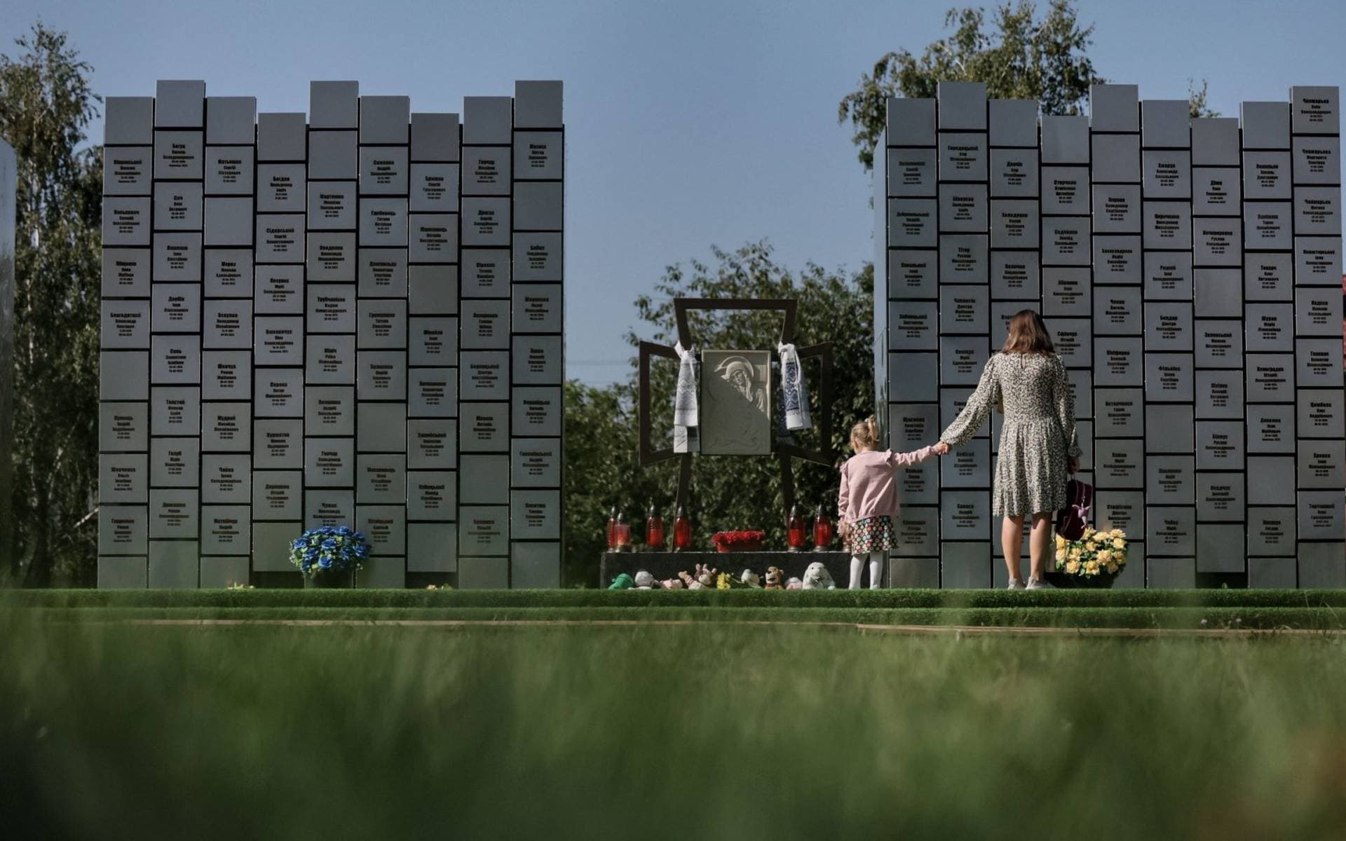 People visit the memorial in a mass grave in Bucha