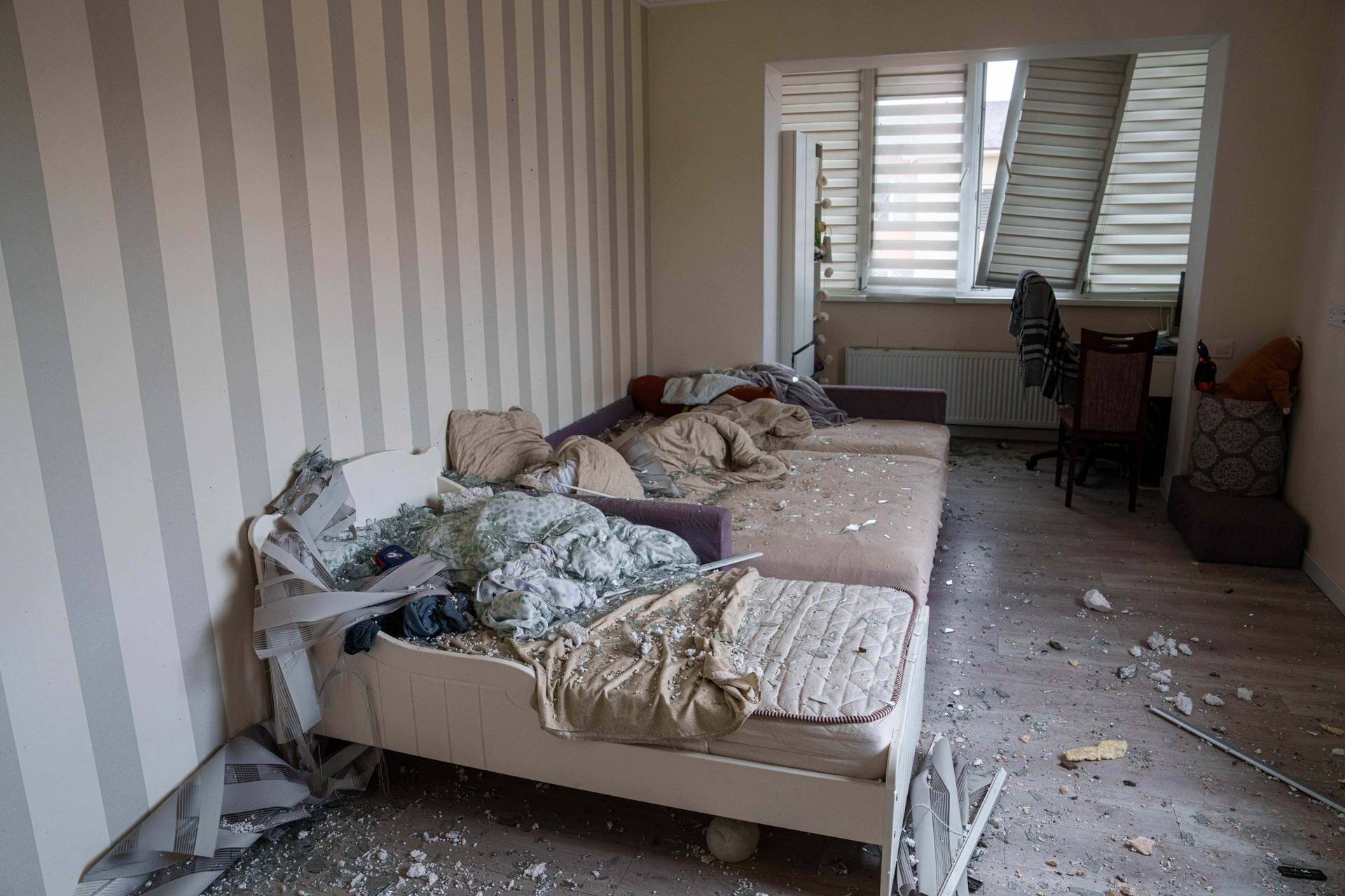 Broken glass is seen on beds at an which was damaged after a Russian strike on residential neighbourhood in Kriukivshchyna