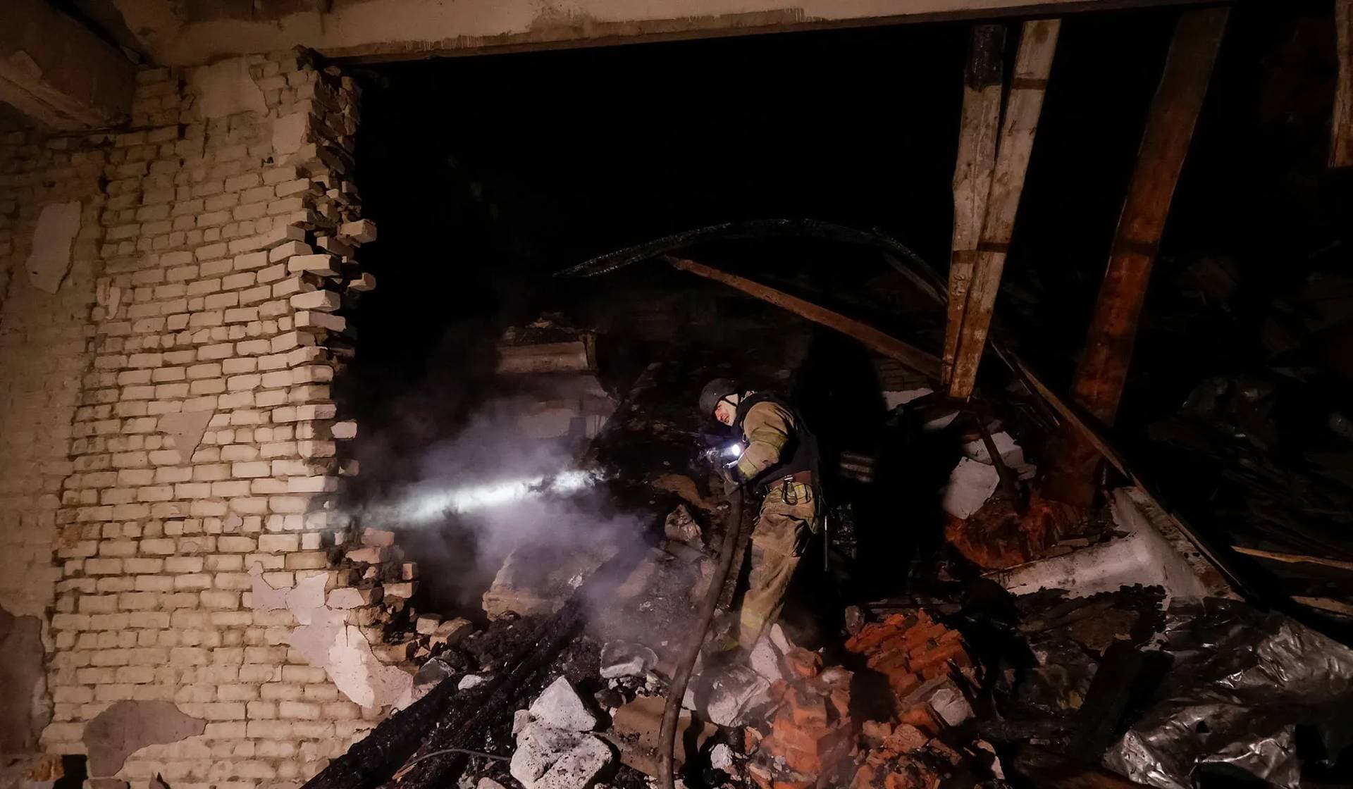 A firefighter works at the site of a Russian drone strike in Chuhuiv, Kharkiv region