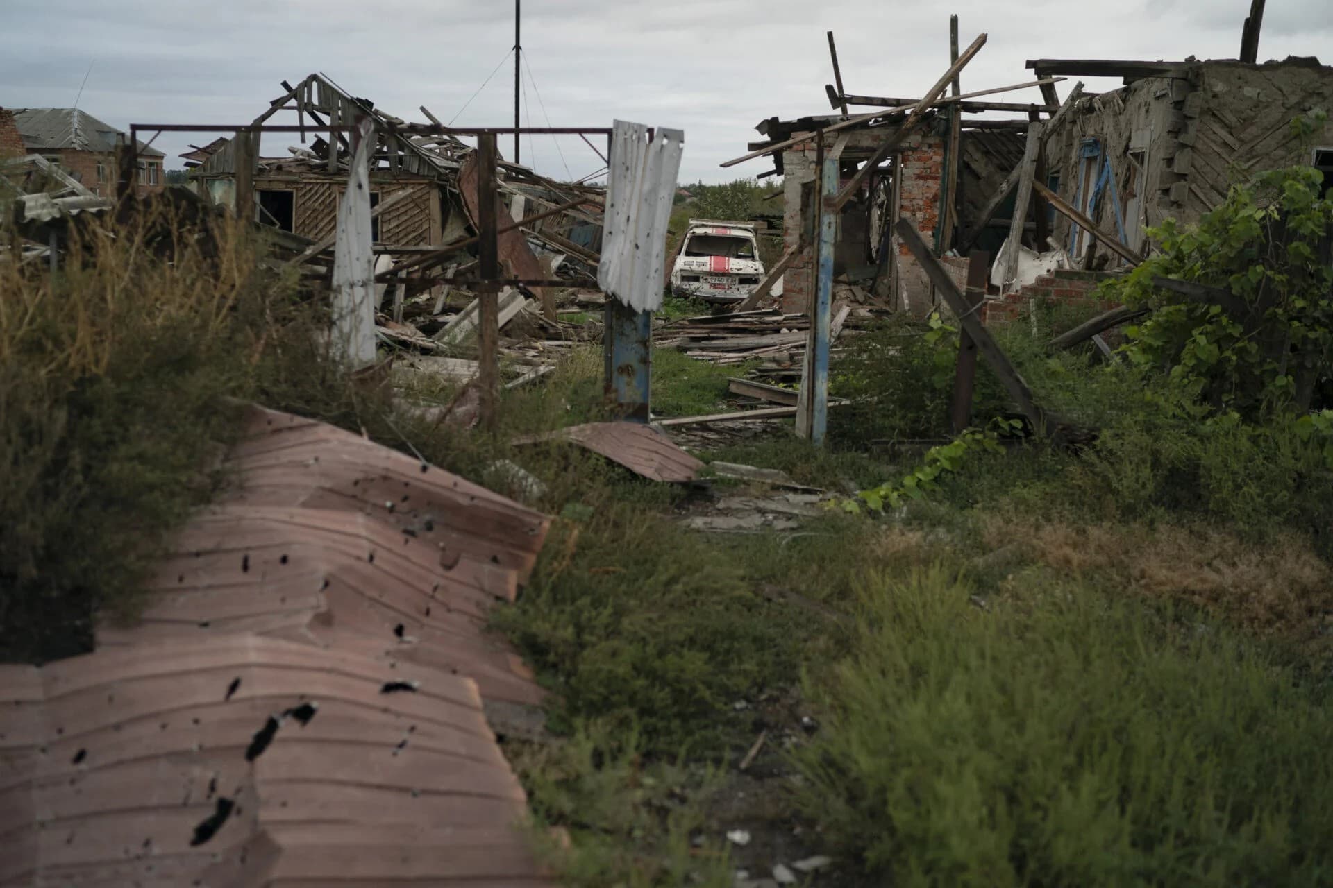 A destroyed car is seen next to heavily damaged houses in the freed village of Hrakove