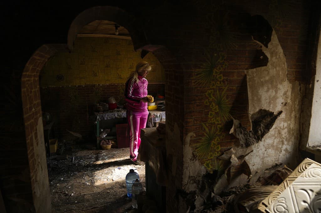 Iryna Martsyniuk stands next to her house, heavily damaged after a Russian bombing in Velyka Kostromka village
