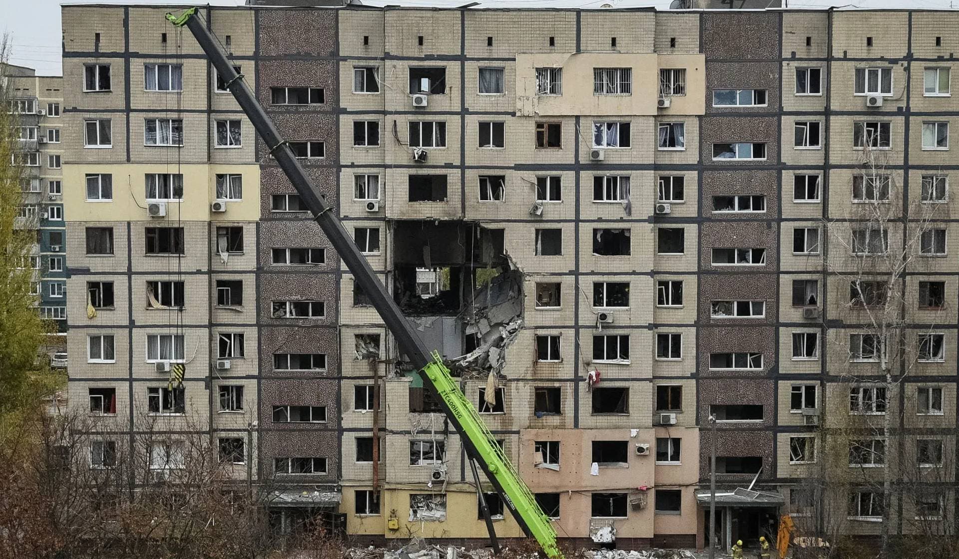 A crane works where several residential units have collapsed after an apartment building was hit during a Russian drone strike, in Dnipro