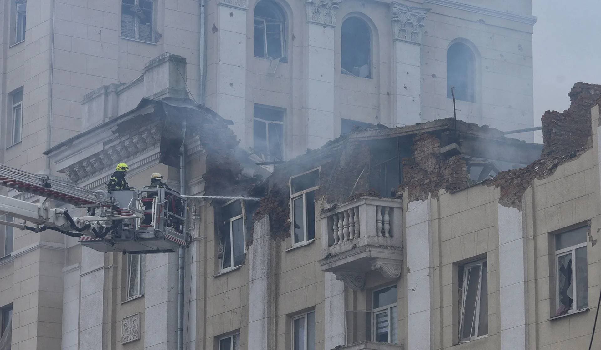 Firefighters work at a site of an apartment building hit by a Russian missile strike in Dnipro