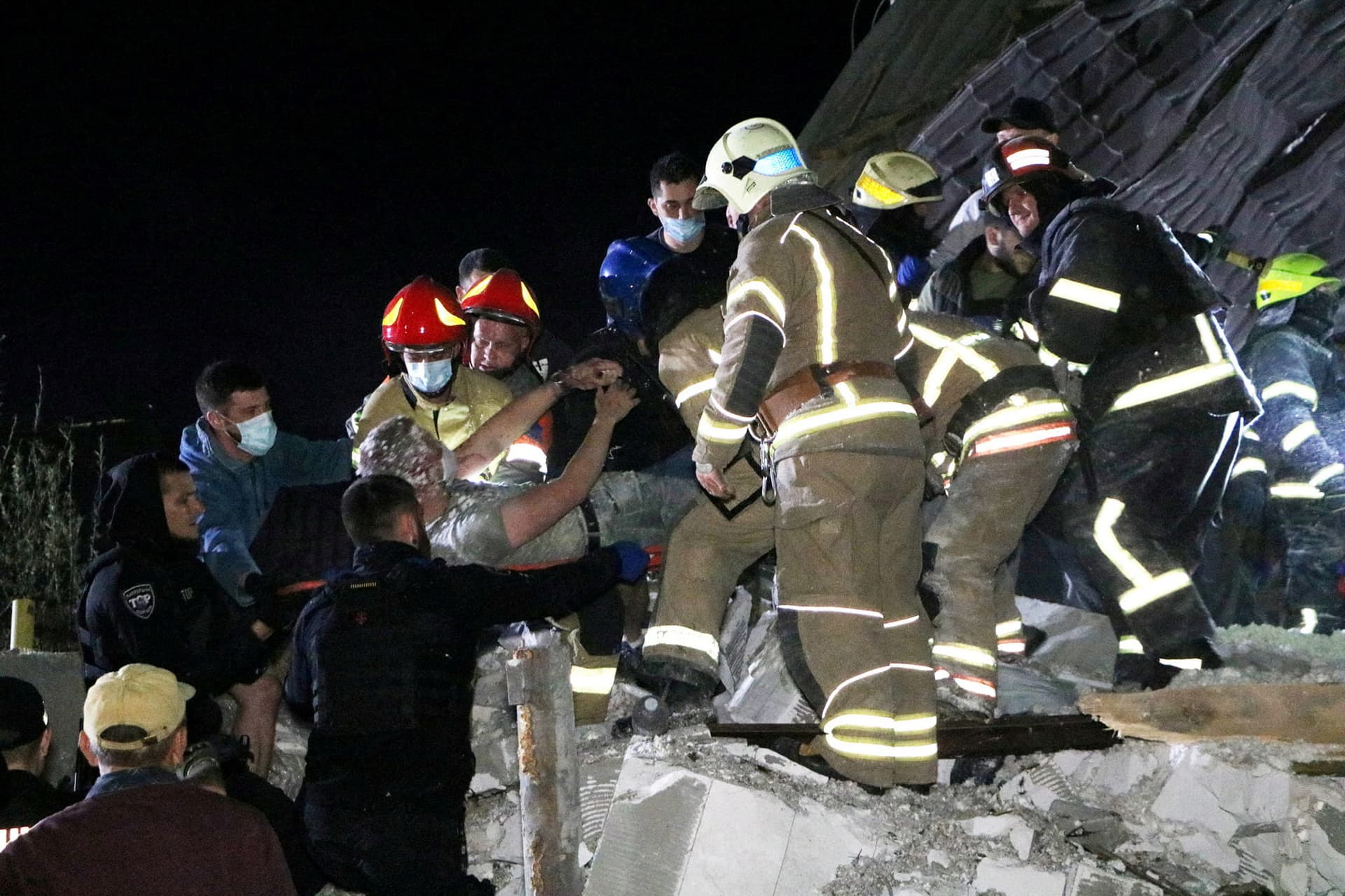 Emergency workers rescue a man from debris of a residential building heavily damaged by a Russian missile strike on outskirt of the Dnipro city