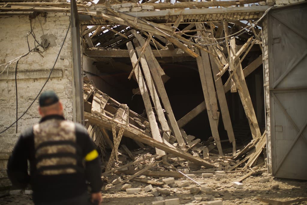Iryna Martsyniuk stands next to her house, heavily damaged after a Russian bombing in Velyka Kostromka village