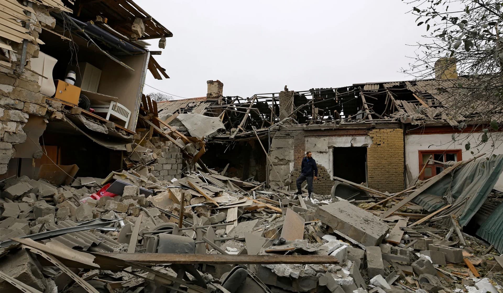 Local resident Alexander stands on the ruins of a house destroyed by recent shelling in Donetsk
