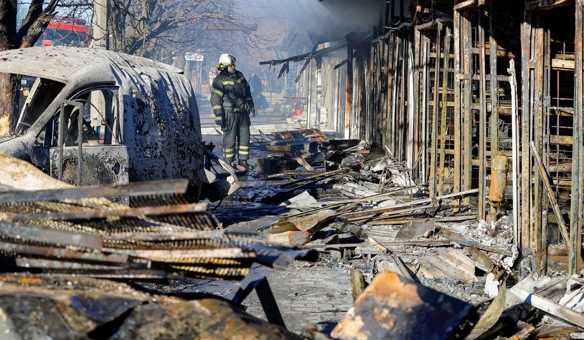 A firefighter stands in front of burned market stalls hit by shelling in Donetsk