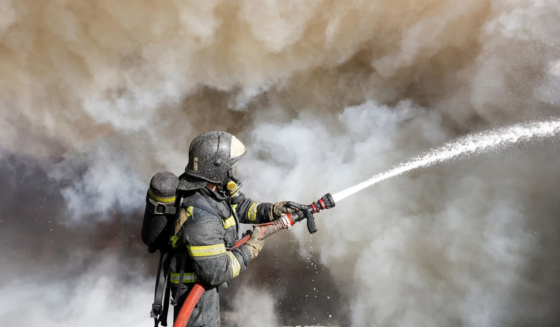 A firefighter works to extinguish fire at market stalls hit by shelling in Donetsk