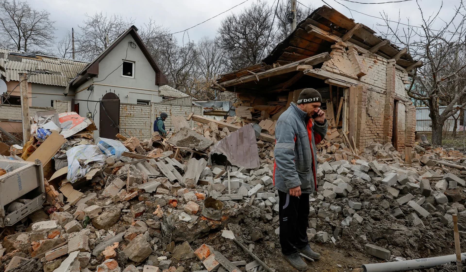 A man speaks on the phone outside buildings damaged in recent shelling in Donetsk