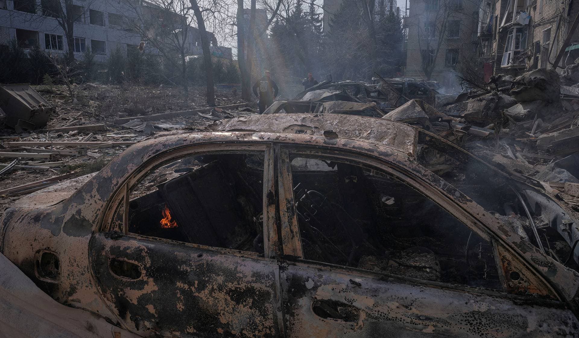 Cars and apartment buildings hit by a Russian air strike in the frontline town of Druzhkivka