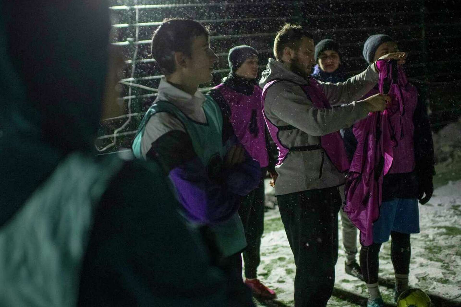 Players prepare for a soccer game during a blackout in Irpin