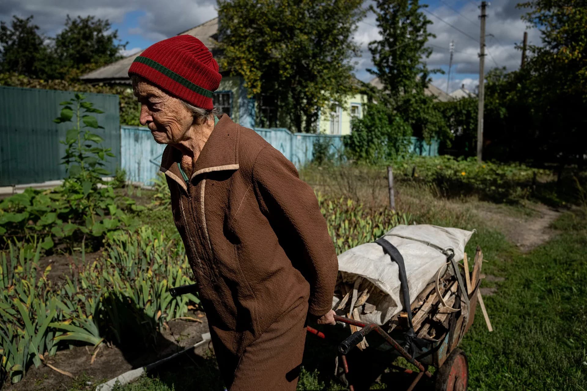 Liudmila Teresenko hauls a cart with wood for heating her house which she took from a destroyed school where Russian forces were based, in the recently retaken area of Izium