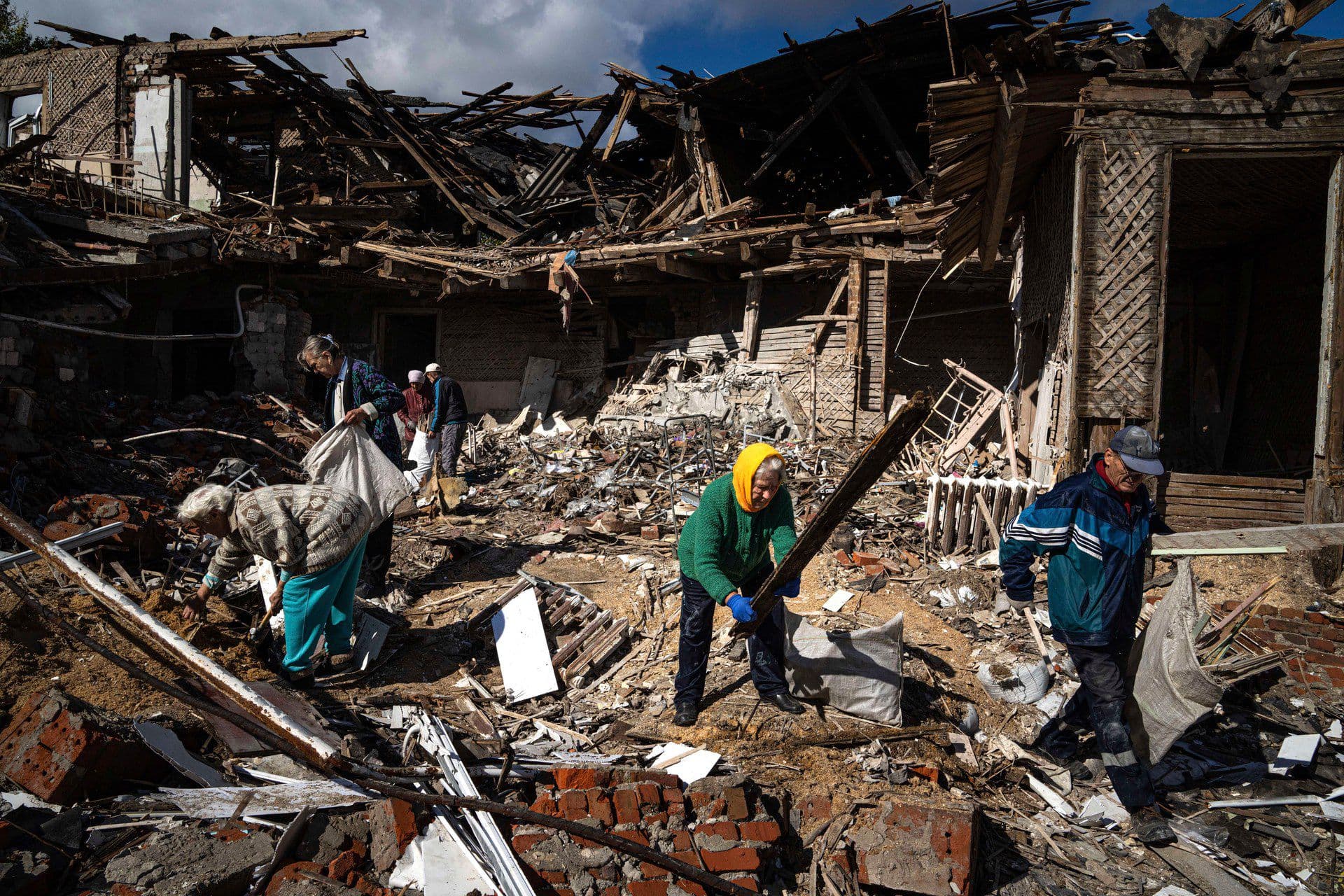 Local residents collect wood for heating from a destroyed school where Russian forces were based, in the recently retaken area of Izium