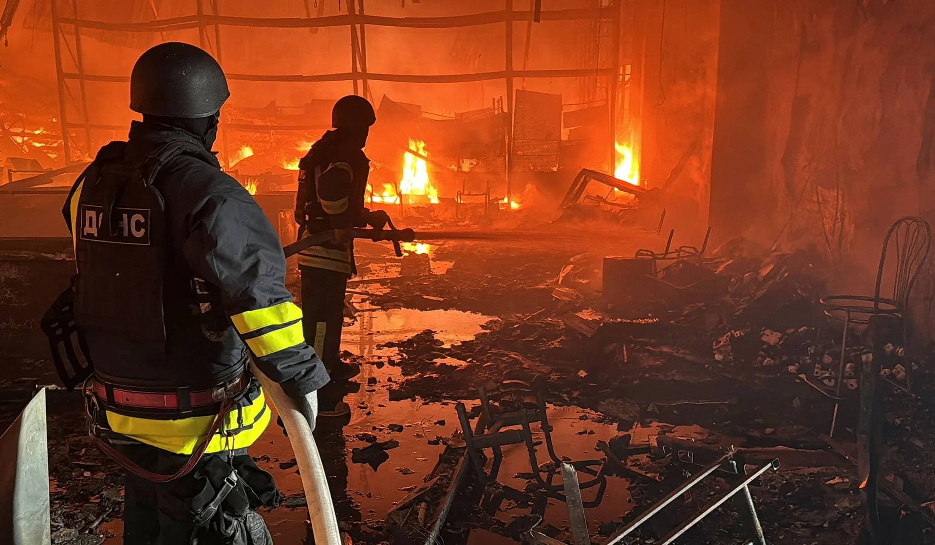 Firefighters work at a site of a household item shopping mall hit by a Russian air strike in Kharkiv