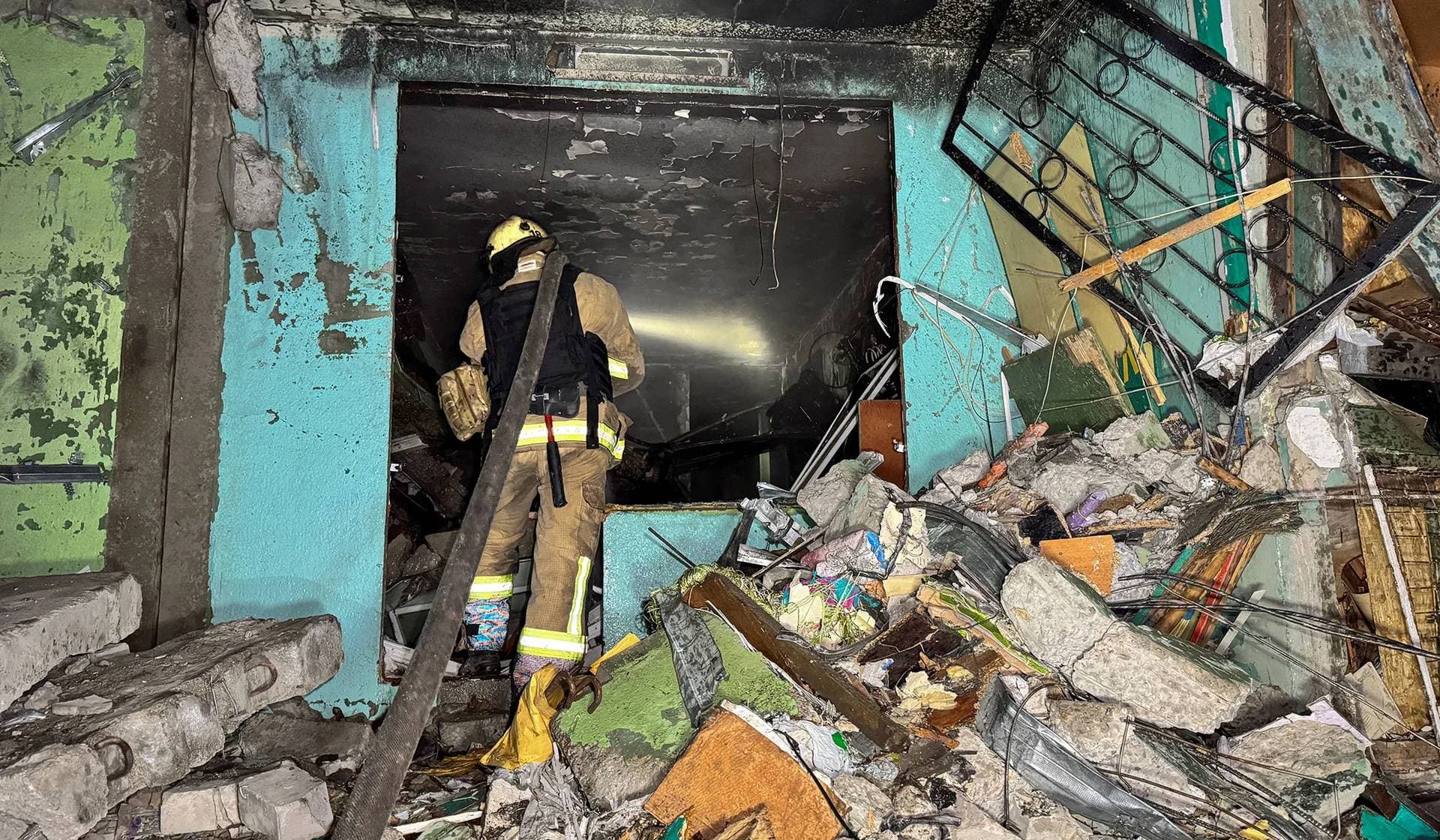 A firefighter works inside an apartment building hit by a Russian air strike in Kharkiv