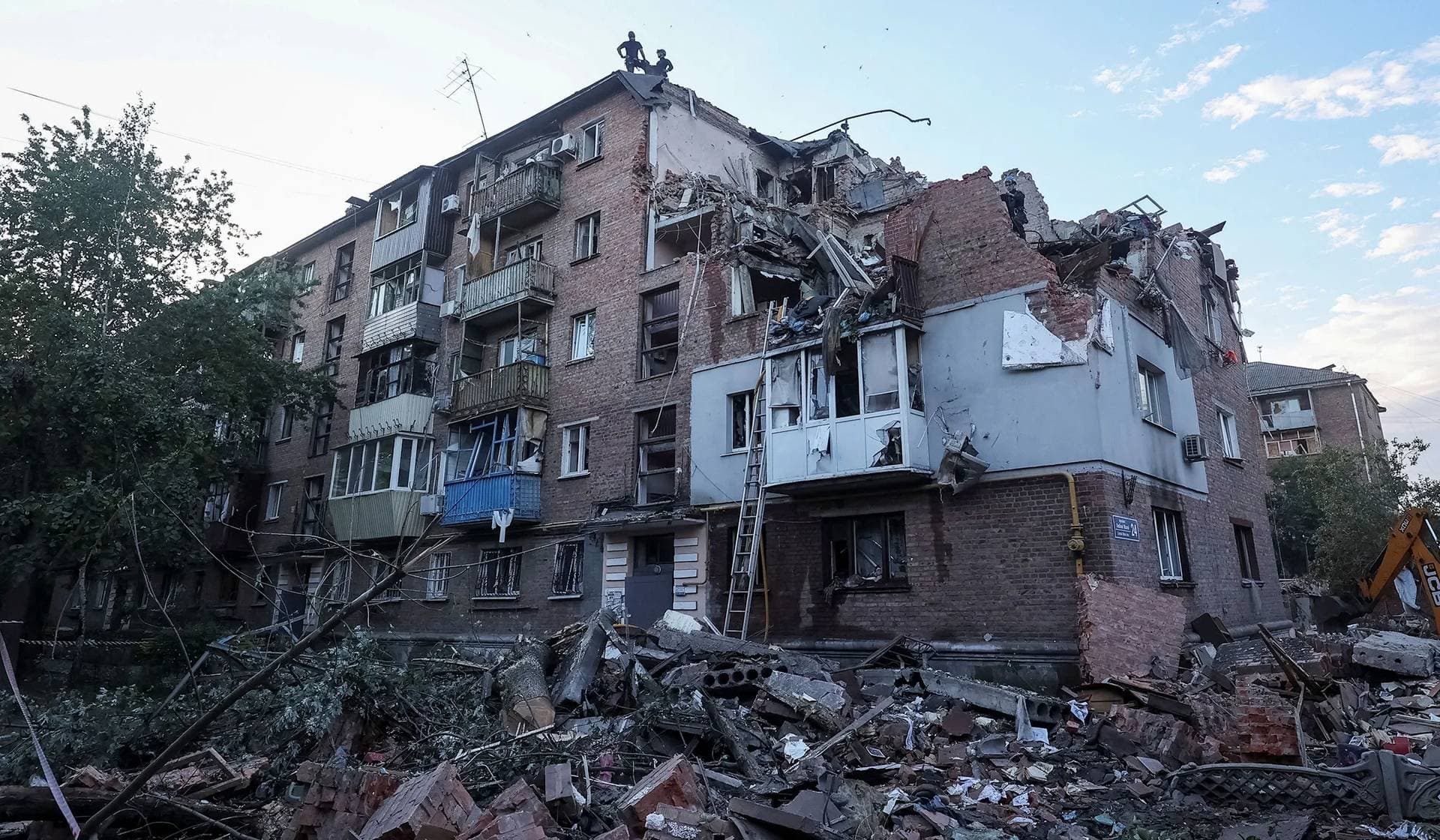 Rescuers work at a site of a residential building hit by a Russian missile strike in Kharkiv