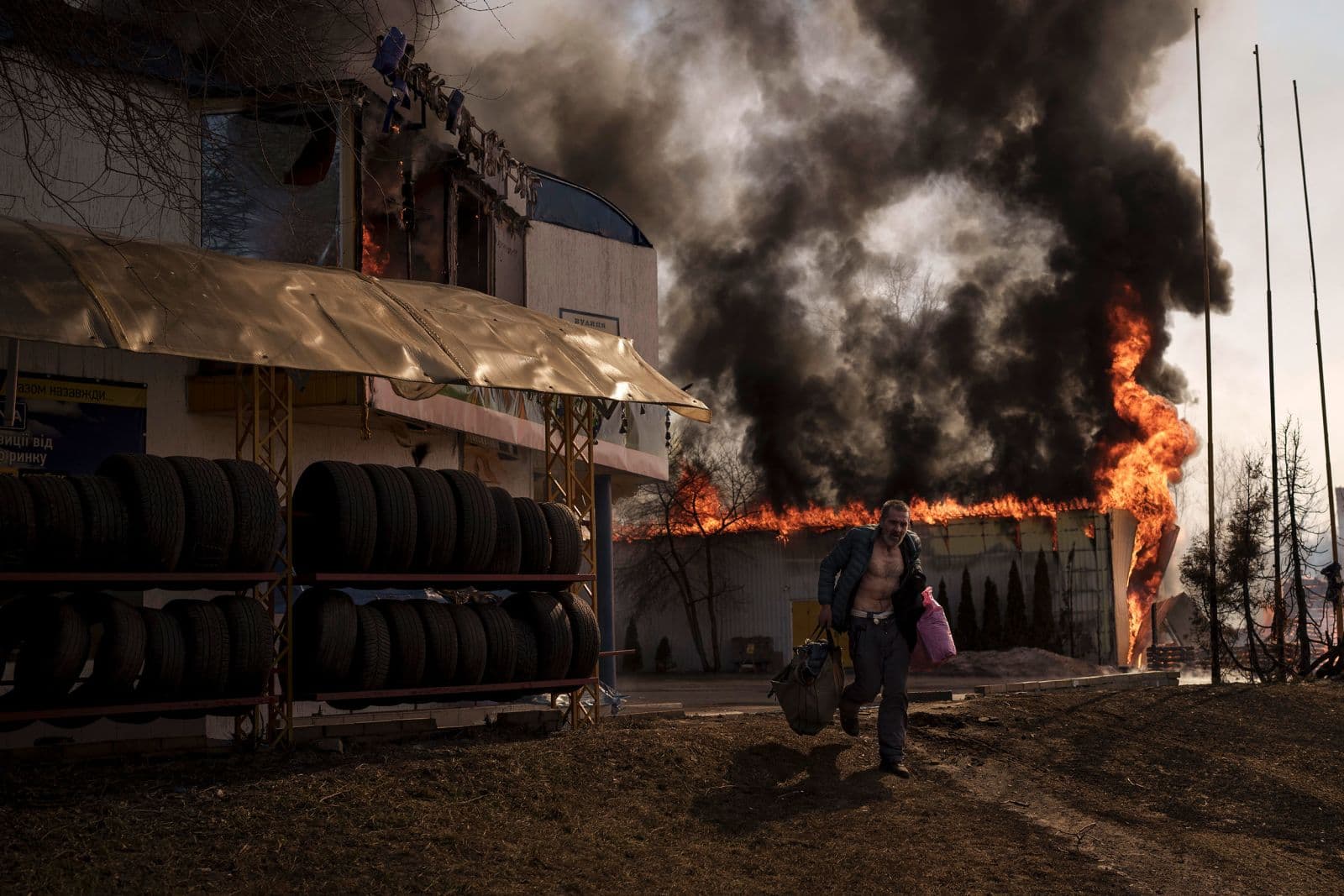 A man recovers items from a burning shop following a Russian attack in Kharkiv