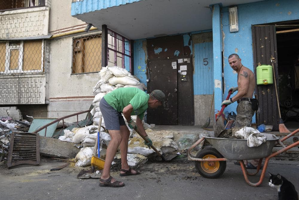 Viktor Lazar cleans the street in front of his apartment in Saltivka district after Russian attacks in Kharkiv