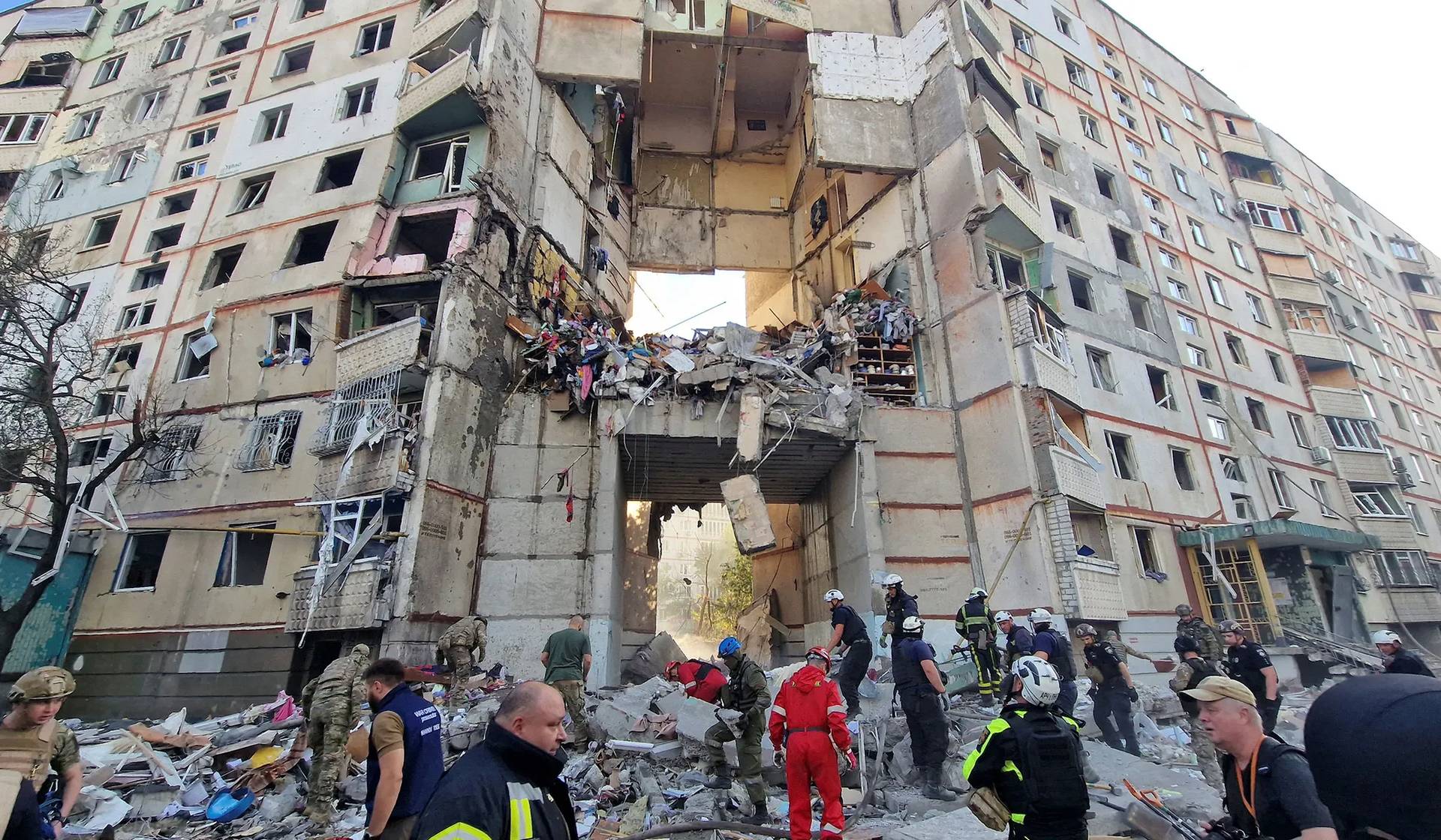 Firefighters and rescuers work at the site of an apartment building hit by a Russian air strike in Kharkiv