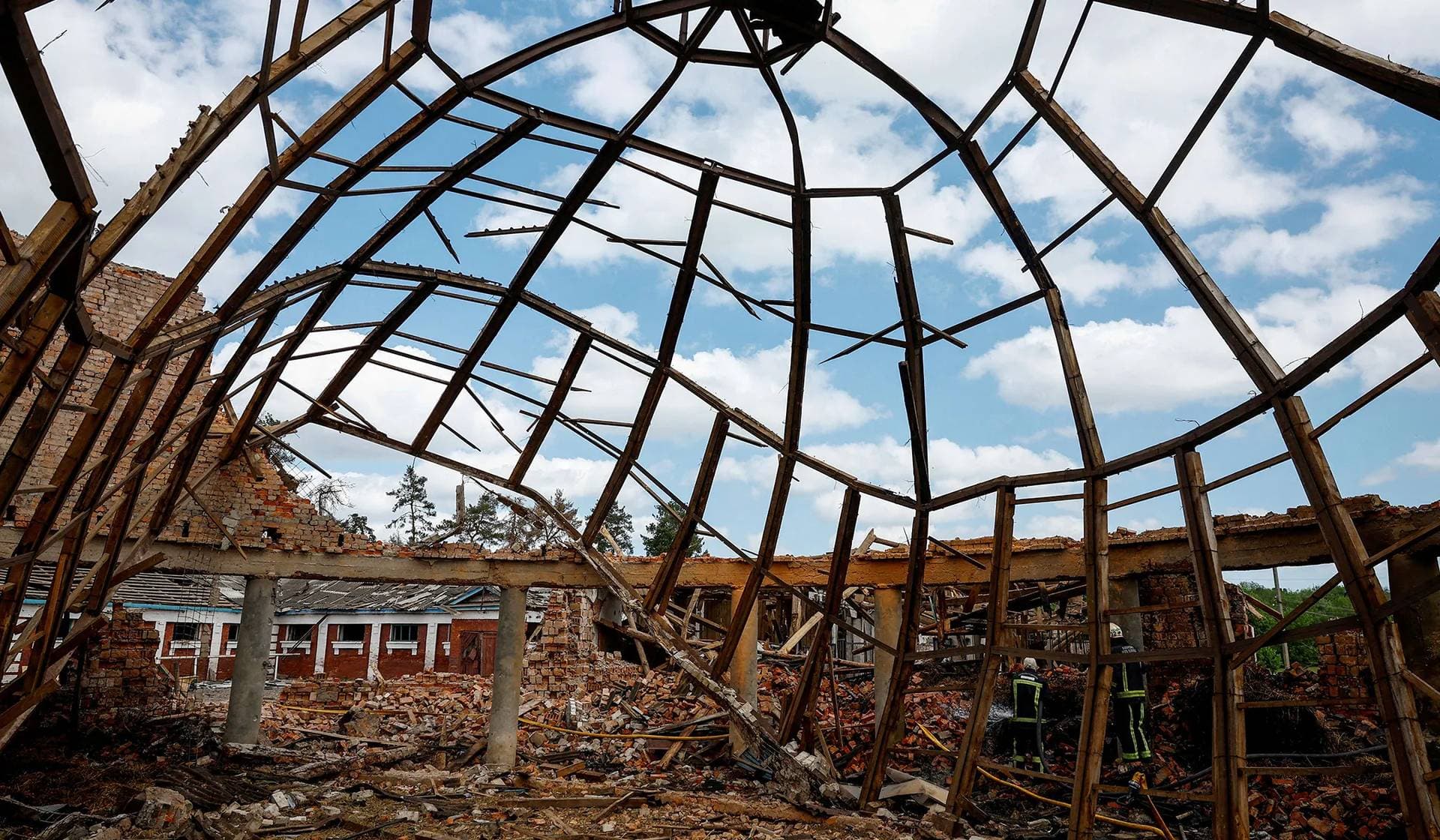 Firefighters work at the site of the Kids and Youth Sport Riding School heavily damaged by Russian missile strikes in the village of Mala Danylivka outside Kharkiv