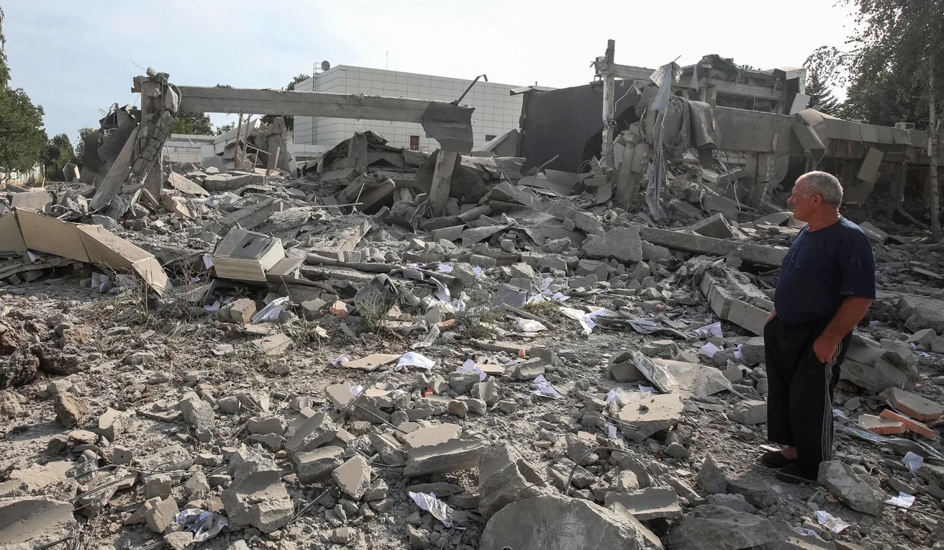 A man observes an Employment Center building destroyed by a night Russian military strike in Derhachi, Kharkiv Region