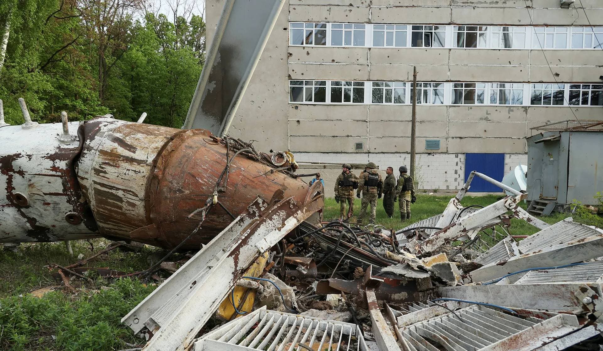Police officers stand next to a part of a television tower partially destroyed by a Russian missile strike in Kharkiv