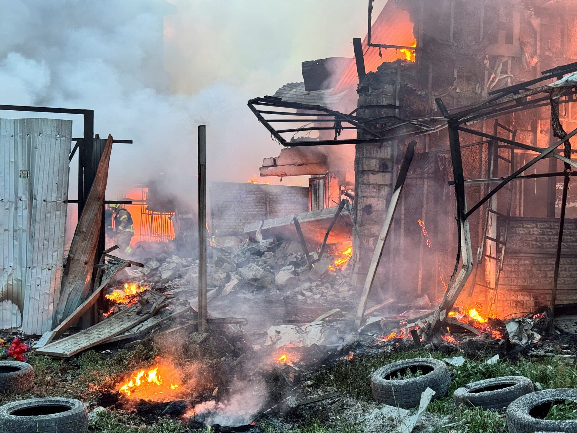Firefighters work at the site of the Russian drone strike in Kharkiv