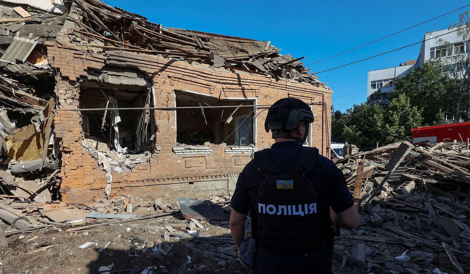 A police officer inspects a residential building heavily damaged by a Russian air strike in Kharkiv
