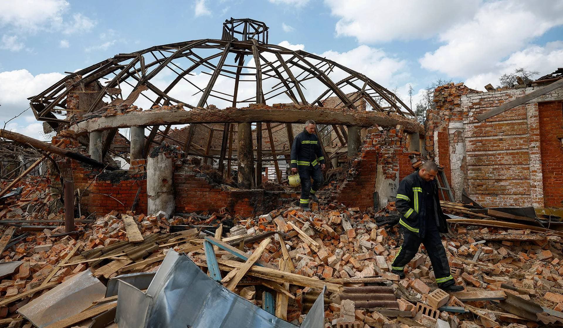 Firefighters work at the site of the Kids and Youth Sport Riding School heavily damaged by Russian missile strikes in the village of Mala Danylivka outside Kharkiv