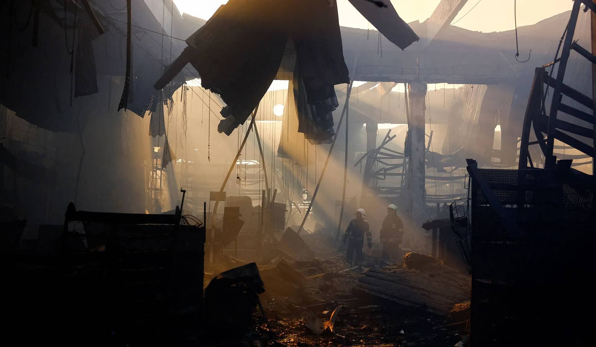 Firefighters work at the site of a household item shopping mall hit by a Russian air strike in Kharkiv