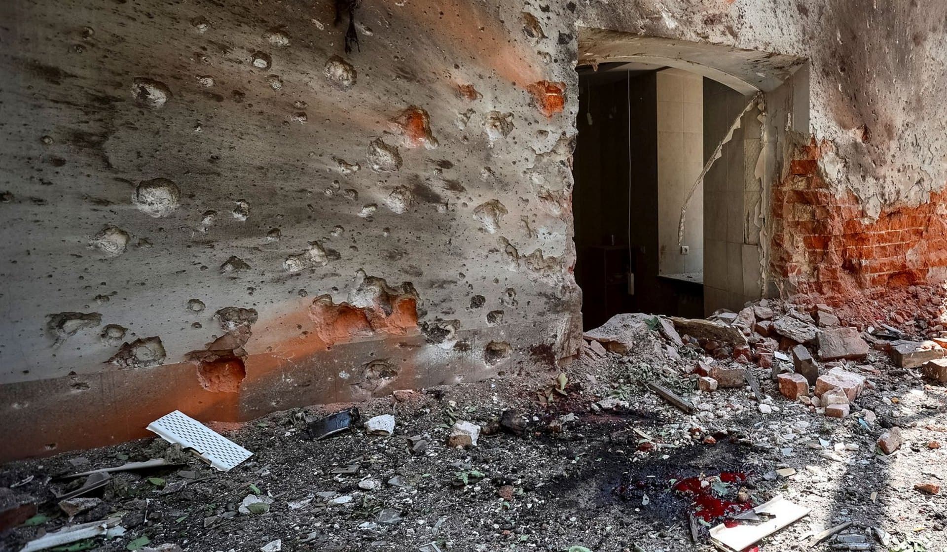 Blood of a wounded local resident in the yard of a residential building damaged by a Russian military strike in Kharkiv