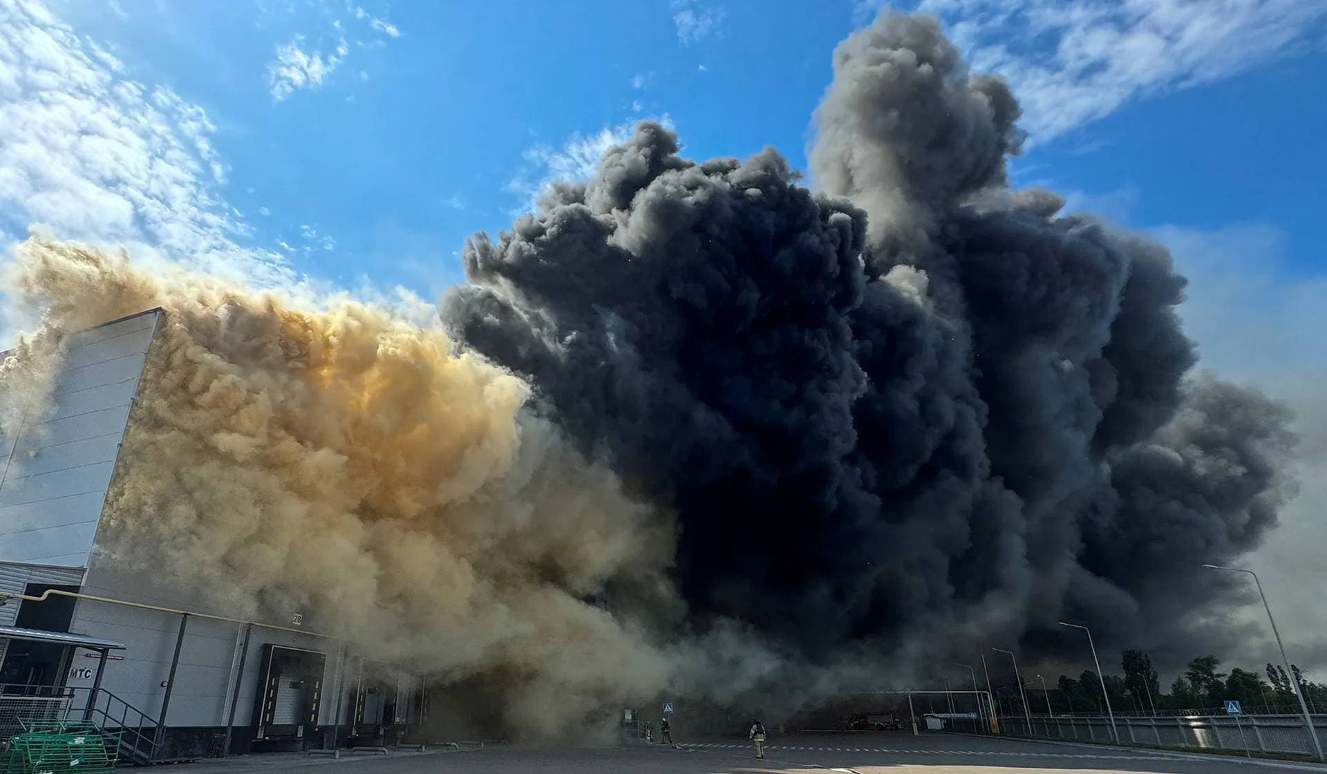 Smoke rises over a compound of a food warehouse hit by a Russian military strike in the village of Vasyshcheve outside Kharkiv
