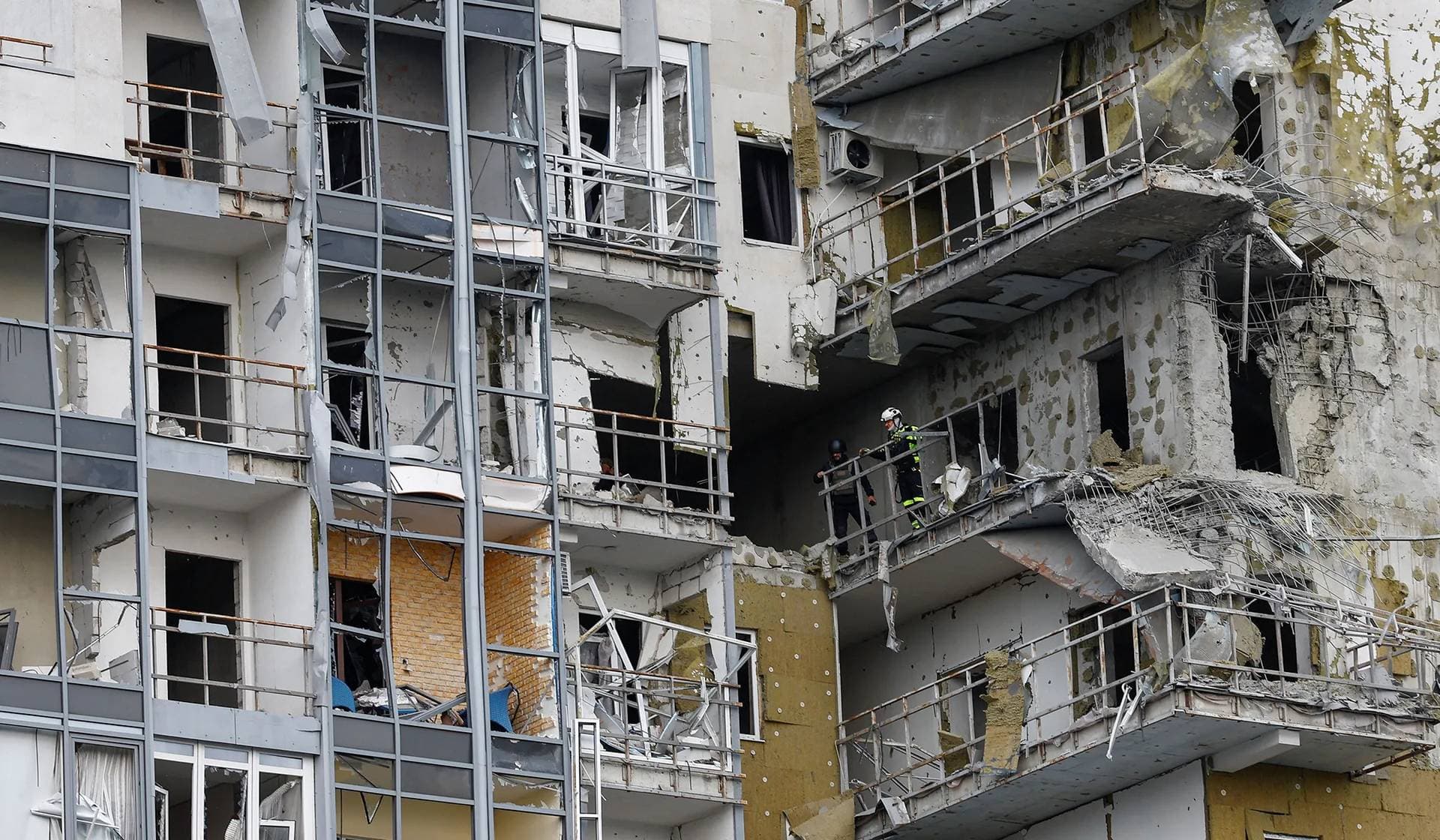 Emergency workers inspect an apartment building damaged by a Russian air strike in Kharkiv