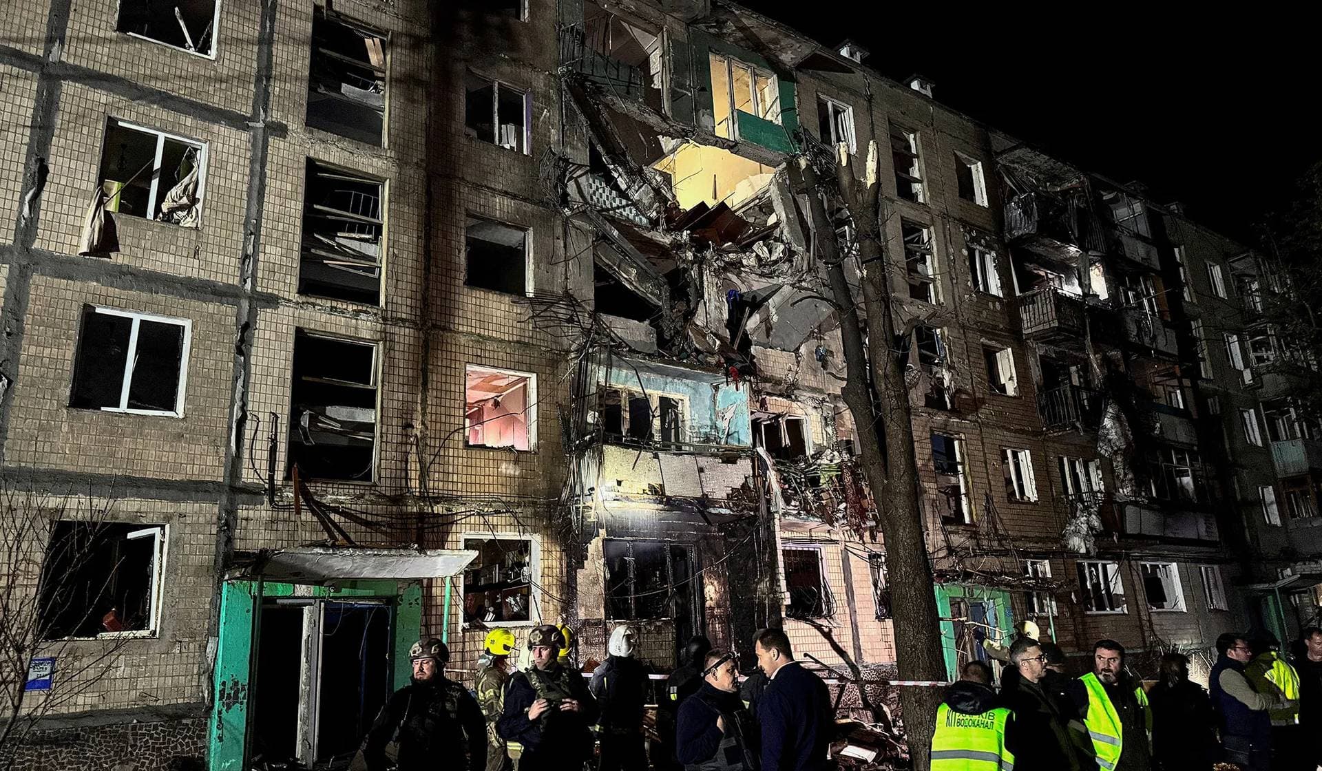 Emergency personnel in front of the apartment building hit by a Russian air strike in Kharkiv