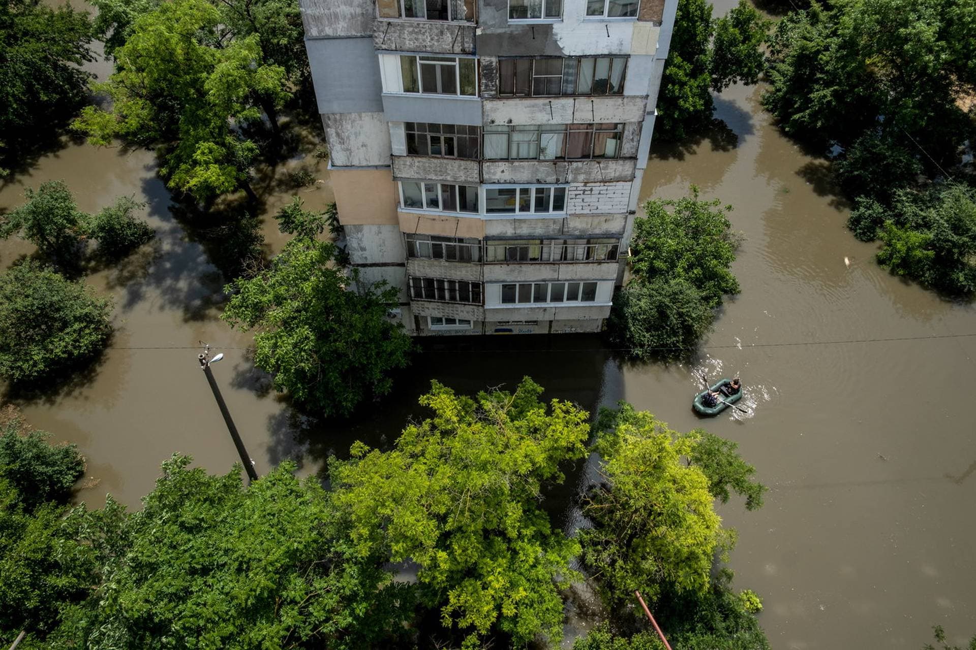 Residents use a rubber boat as they evacuate from a flooded area of Kherson